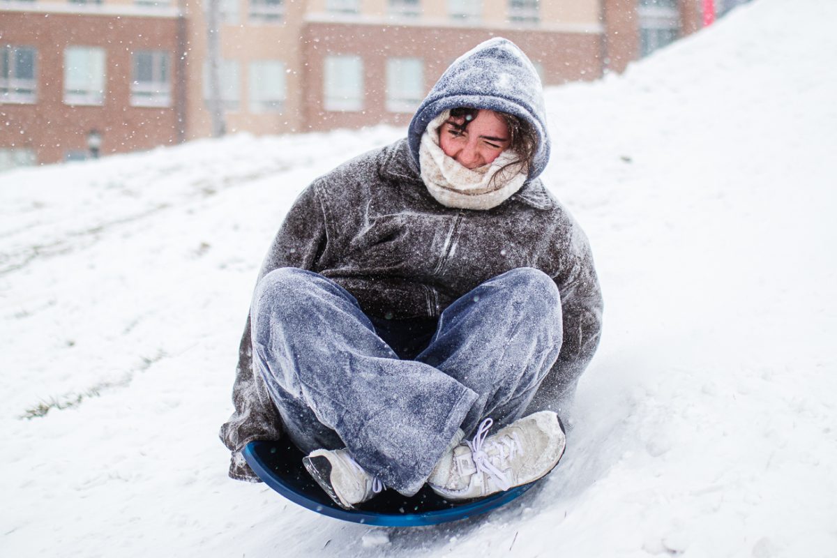 A Wichita State student sleds down the hill between Shocker Hall and Koch Arena on Jan. 24. Many students and visitors came to sled, snowboard and slide down the hill in the freezing temperatures.