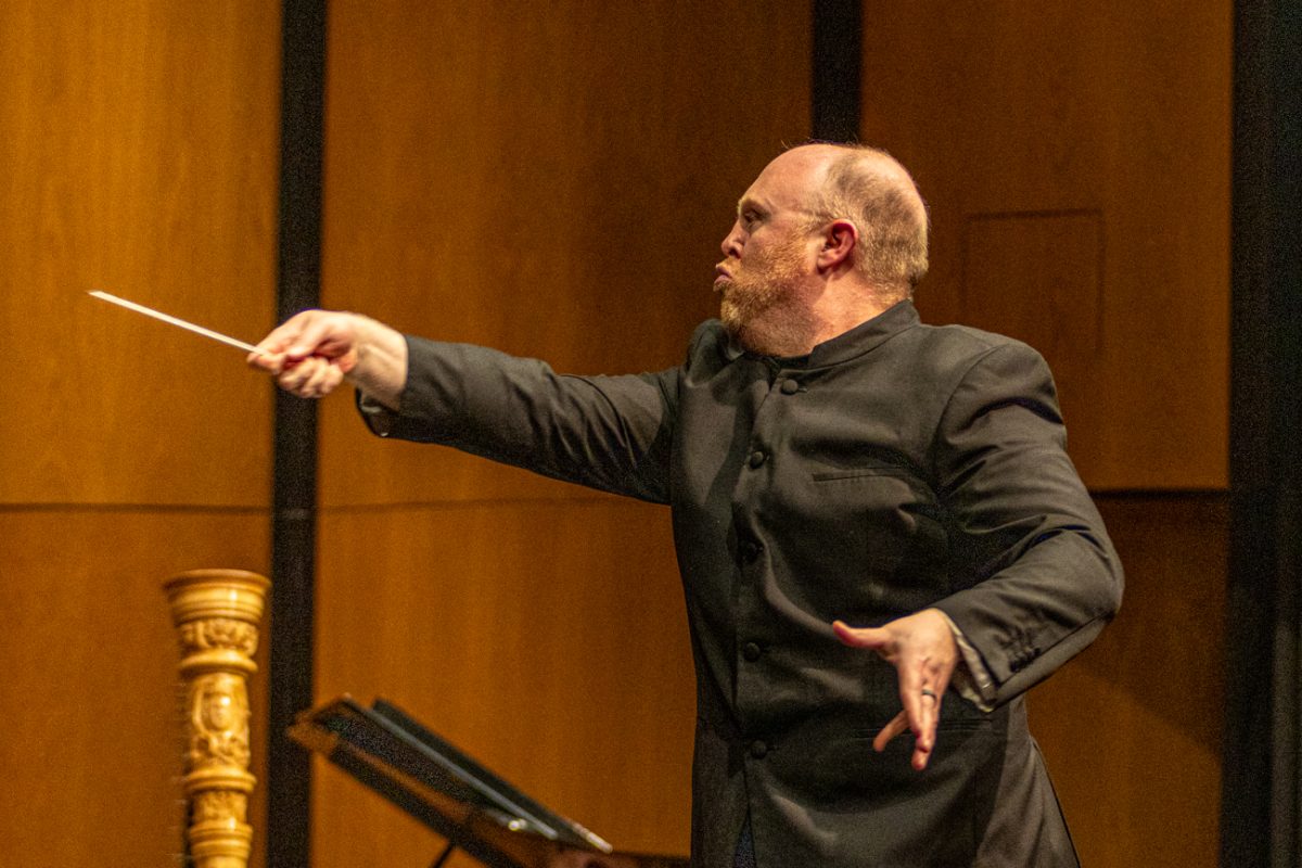 Timothy Shade, conductor for the Wind Ensemble, director School of Music and director of Bands, uses his baton to conduct the concert on Feb. 17. The ensemble played four pieces.