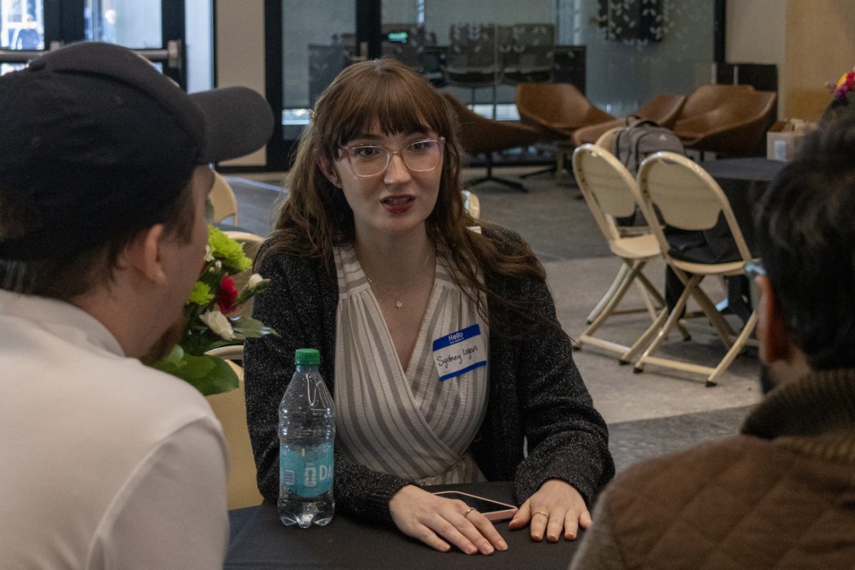 Sydney Logan talks to peers in between the award ceremony and dinner at the ERPSim competition. Teams were made up of three or four students.