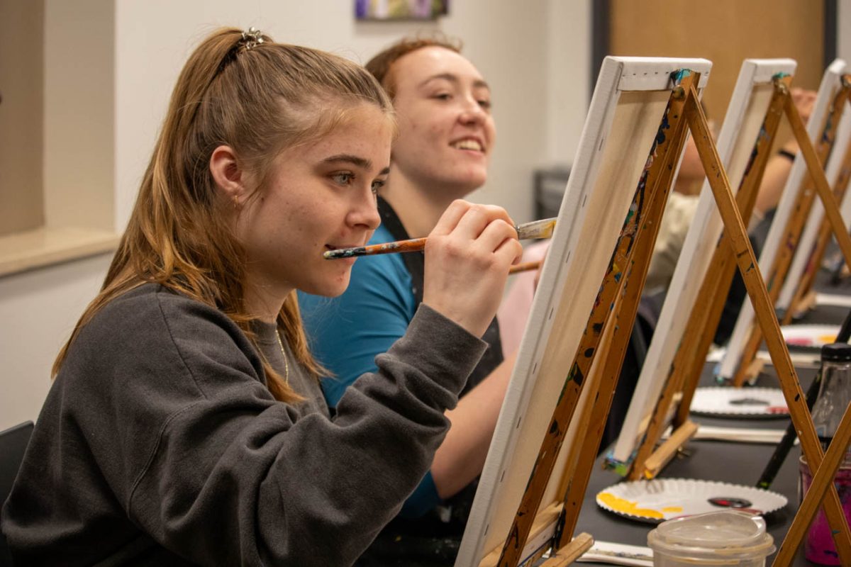 Madelyn Welch and Emma Ratford participate in the Student Activities Council's Paint the Night event. The event was led by business Paint the Towne, which run two studios in Wichita.