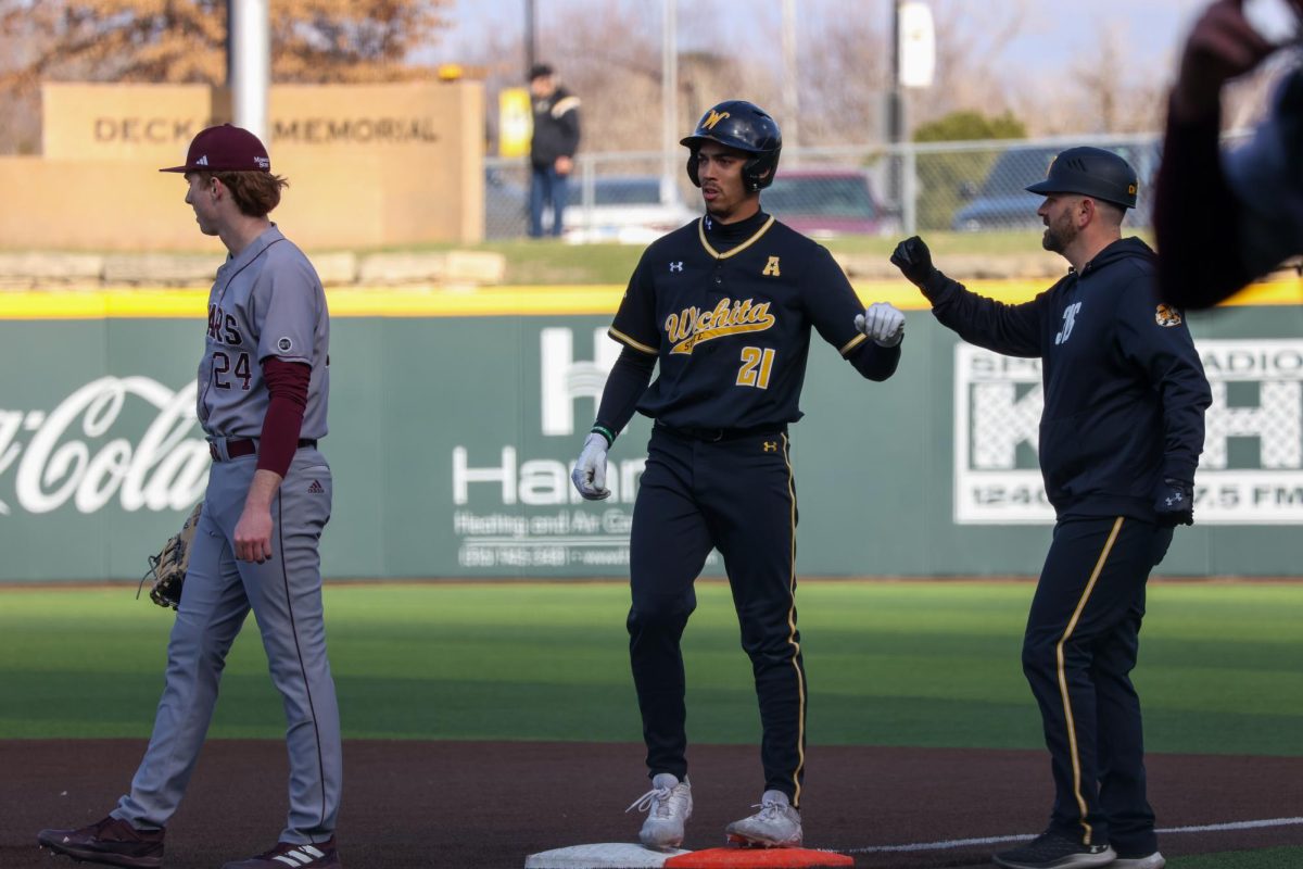 Wichita State baseball outfielder Jaden Gustafson (21) fits bumps Director of Operations Tad Reida during a game against Missouri State on March 7, 2025. (File photo)