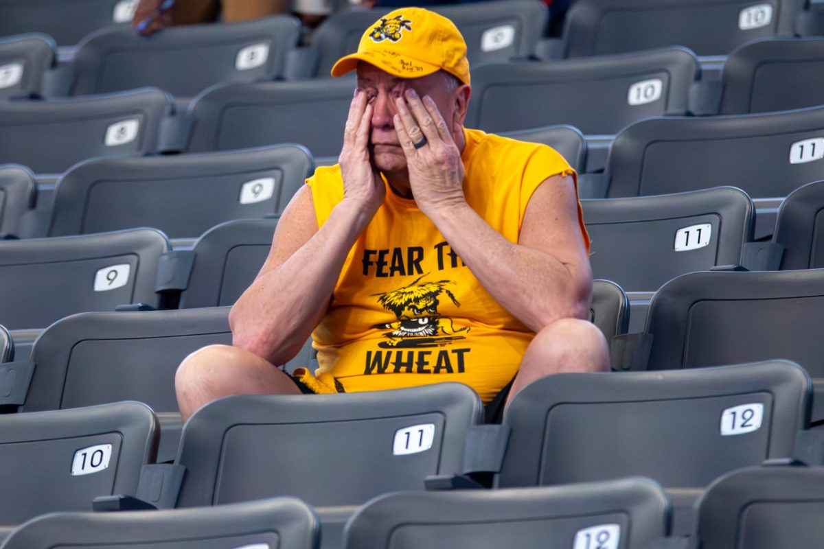 A Wichita State men's basketball fan rubs their eyes during the Shockers conference championship game against South Florida on March 15. The Shockers lost, 70-55.