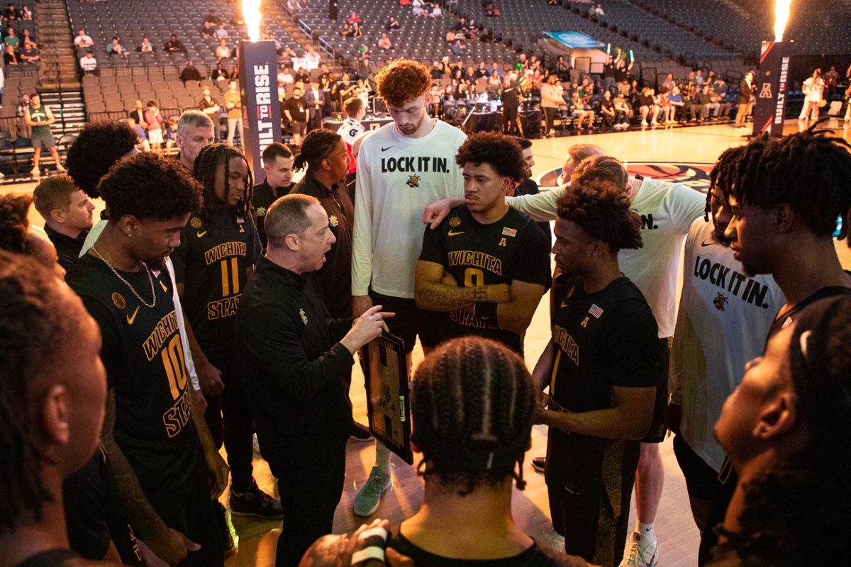 Wichita State men's basketball head coach Paul Mills talks to the team while the opponents are introduced against South Florida on March 15 at Legacy Arena in Birmingham, Ala. The game concluded Mills' third conference tournament with the Shockers.