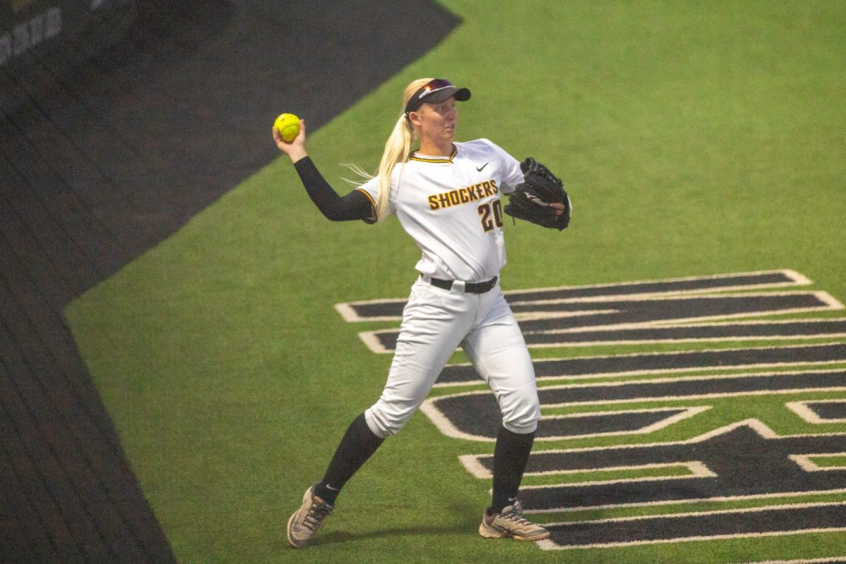 Wichita State softball freshman infielder Kinzey Woody (20) throws a ball from foul territory against Florida Atlantic on March 20 at Wilkins Stadium. The Shockers won, 3-2.