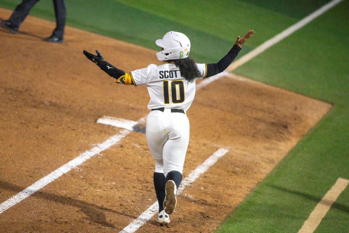 Wichita State softball sophomore catcher Gabby Scott (10) throws her hands up while rounding first base against Florida Atlantic on March 20 at Wilkins Stadium. Scott had just hit a solo home run to tie the score at two during the Shockers' eventual 3-2 win.