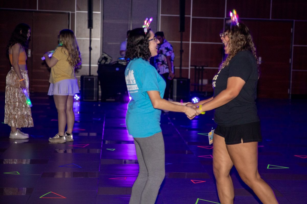 Students dance to music from a live DJ at the Student Activities Council's Neon Night Out on March 25. The event had glowing face paint and glowing games.
