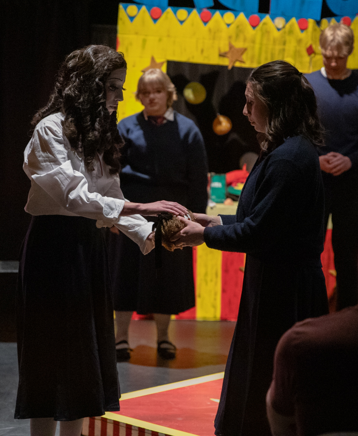 Sophia Fruits hands Aubrey Johnson her doll. Johnson played Jane Doe in "Ride the Cyclone."