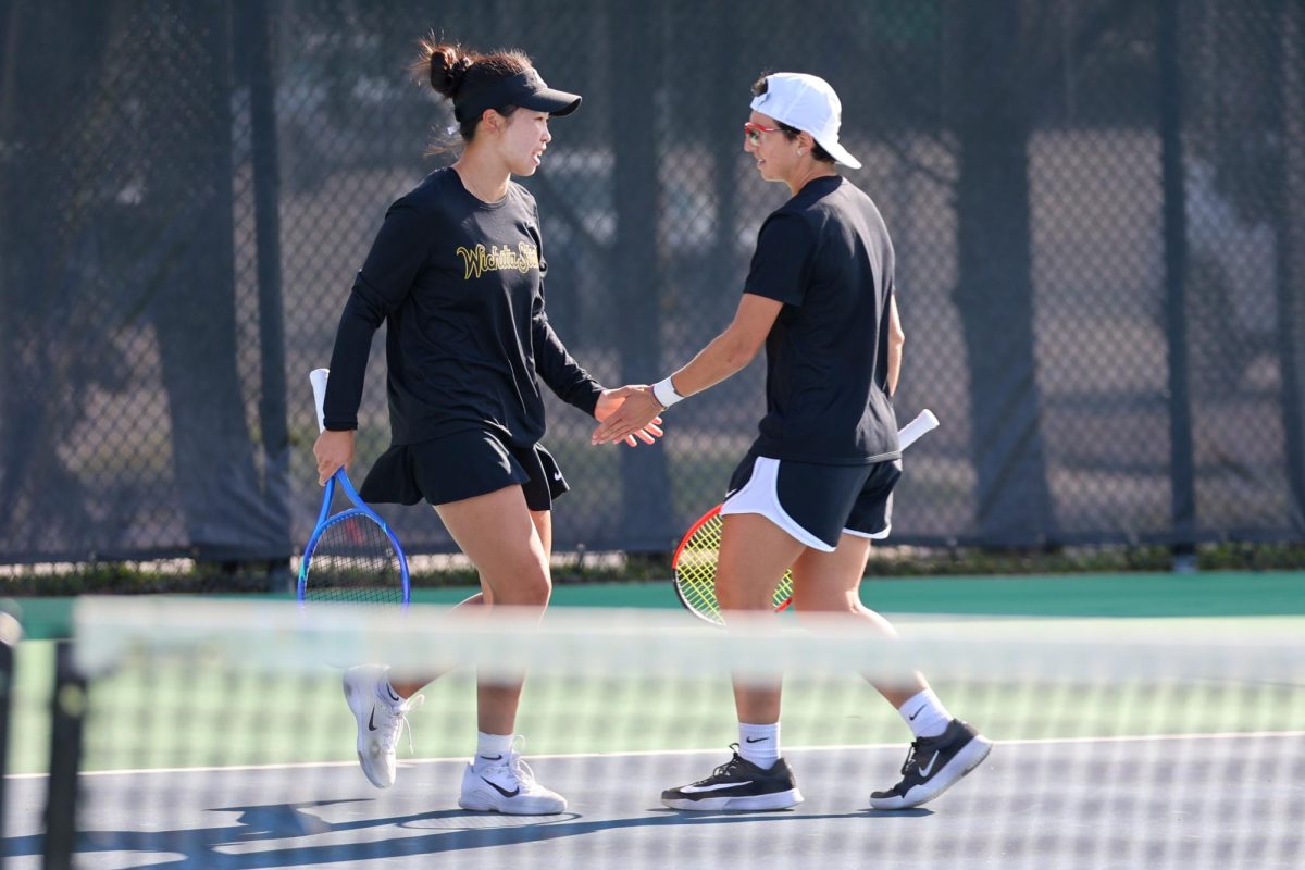 Wichita State women's tennis players Xin Tong Wang, left, and Giorgia Roselli high-five during a match against South Florida on March 27 at the Sheldon Coleman Tennis Complex. The Shockers won via sweep and extended their win streak to 13.