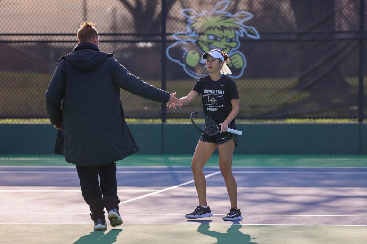 Wichita State women's tennis senior Vichitraporn Vimuktananda high-fives assistant coach Chad Kissell during a match against South Florida March 27 at the Sheldon Coleman Tennis Complex. Vimuktananda and Kissell are both in their first year at Wichita State.
