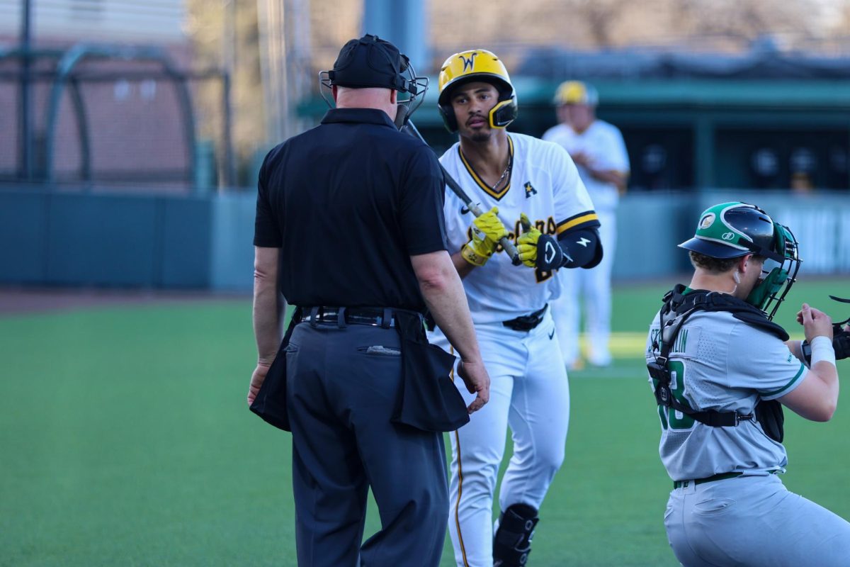 Wichita State baseball junior outfielder Kaleb Duncan (26) talks to home plate umpire before an at bat against Charlotte on March 20 at Eck Stadium. Duncan was walked once and made an RBI against the 49ers.
