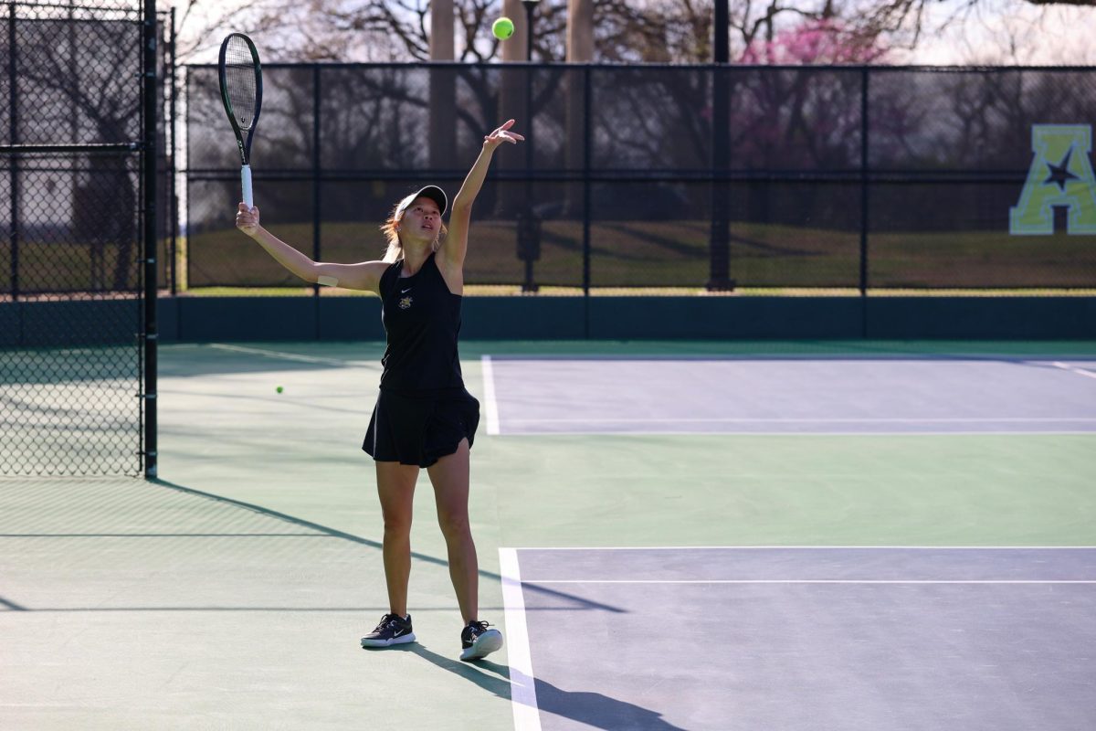 Wichita State women's tennis senior Vichitraporn Vimuktananda tosses the ball to serve against South Florida March 27 at the Sheldon Coleman Tennis Complex. Vimuktananda is in her first year at WSU after transferring from Central Arkansas.