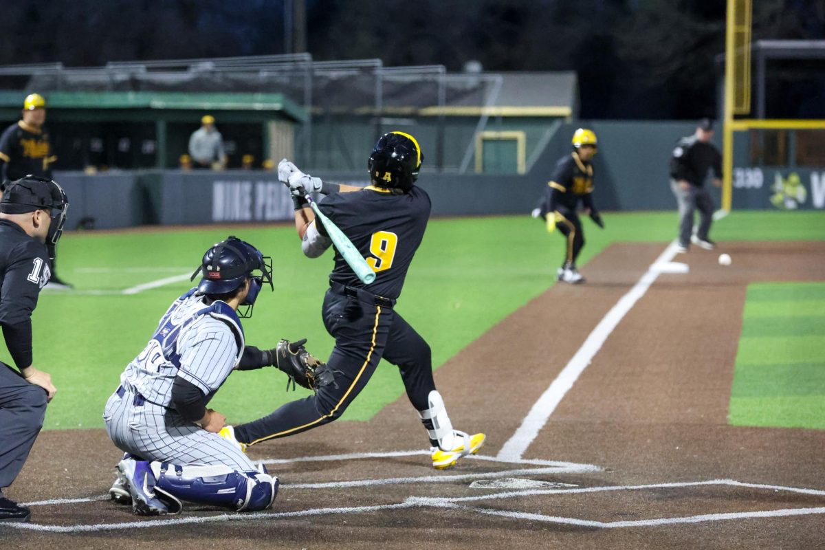 Wichita State baseball sophomore Evan Escobar (9) hits a ball to his left against Butler on March 12 at Eck Stadium. The Shockers swept the Bulldogs in a four-game series.