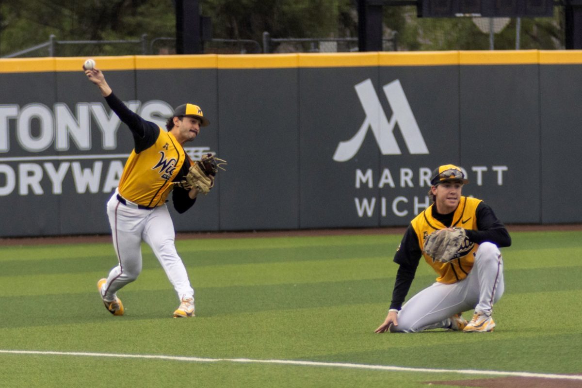 Wichita State baseball senior infielder Alex Ulloa (8) fires the ball from the outfield while junior infielder Zeb Henry (1) crouches against No. 11 Kansas on April 28 at Eck Stadium. The Shockers lost, 14-1.