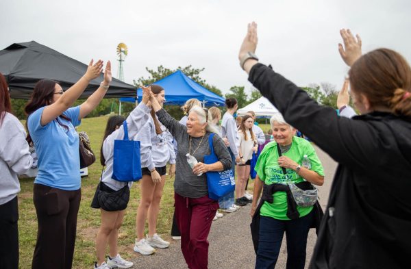 A pair of finishers are celebrated at the 2026 NAMIWalks walk at Sedgwick County Park. The event acted as a fundraiser on top of spreading awareness.