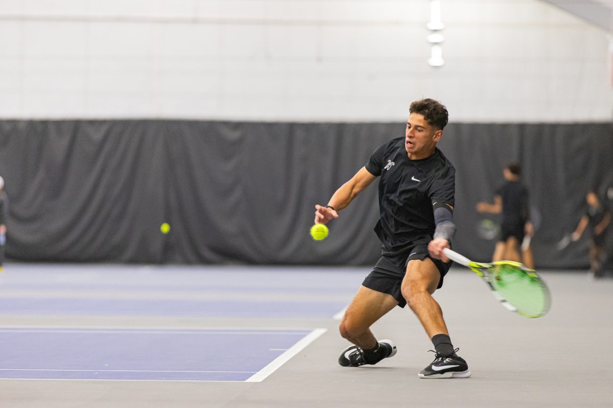 Wichita State men's tennis sophomore Zaid Al Mashni reaches low to strike the ball during a singles match on March 1. (File photo)