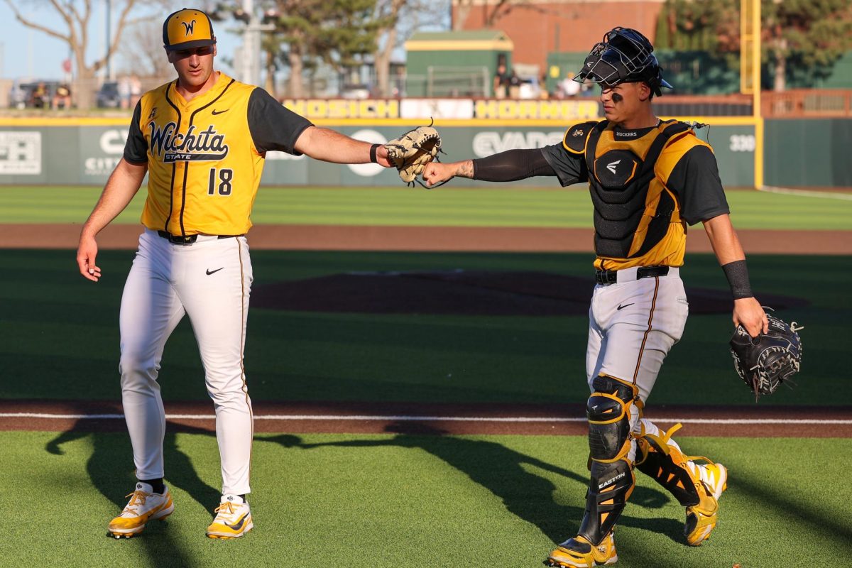 Wichita State baseball juniors Matthew Cuccias (18) and Ethan Gonzalez (3) fist bump at the end of the first inning against Tulane on April 2 at Eck Stadium. Cuccias and Gonzalez were the Shockers' battery mates to start the game.