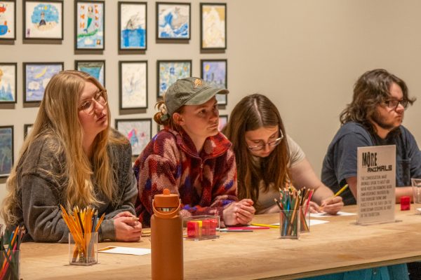 Attendees of the "Symbols of Greatness" talk watch and listen to the presentation by Wichita State faculty on April. 30.