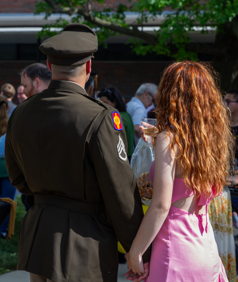 Graduate Rafael Guereque stands with his guest after the ceremony of The Toast. The event was held at the Rhatigan Student Center's east courtyard.