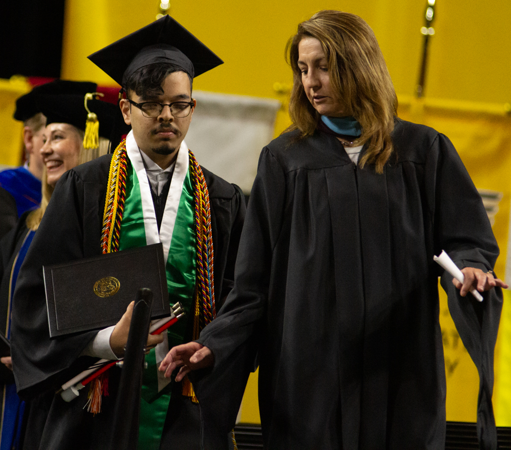 Graduate Hashim Syed walks down the stairs during commencement on May 16. Syed graduated with a degree in communications.