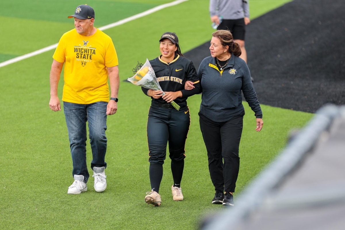 Senior Chloe Rhine walks out with her parents during the senior celebration. Rhine is in her first year at WSU after spending her first three years at Saint Louis.