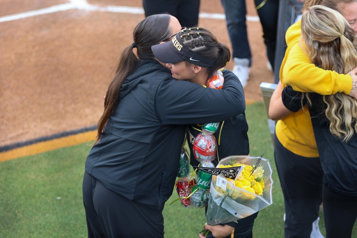 Senior Jodie Epperson hugs WSU softball pitching coach Courtney Oliver-Elkins. Epperson played her final two collegiate seasons for the Shockers.