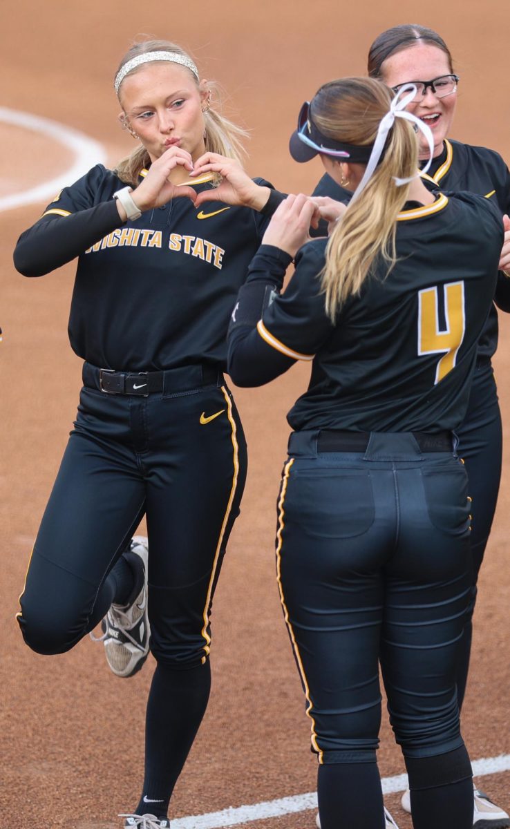 Sophomore Gabby Fakes and  graduate student Johnna Schroeder make a heart shape with their hands before the game on Friday. Fakes and Schroeder both are in their first year at WSU.