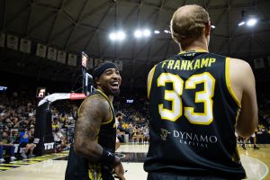 AfterShocks Guard Marcus Keene laughs with Guard Conner Frankamp while celebrating a made shot by another player.