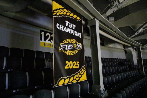 The AfterShocks 2025 TBT Champions banner hangs in the rafters in Charles Koch Arena. The AfterShocks were the first alumni team to hang a banner on their home court.